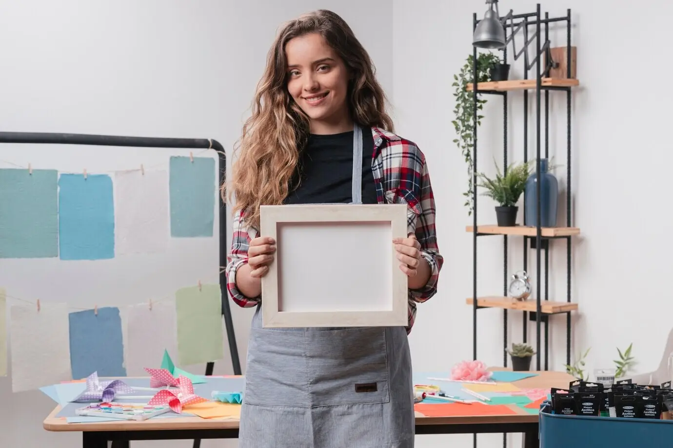Fröhliche, hübsche Frau hält einen leeren weißen Fotorahmen.