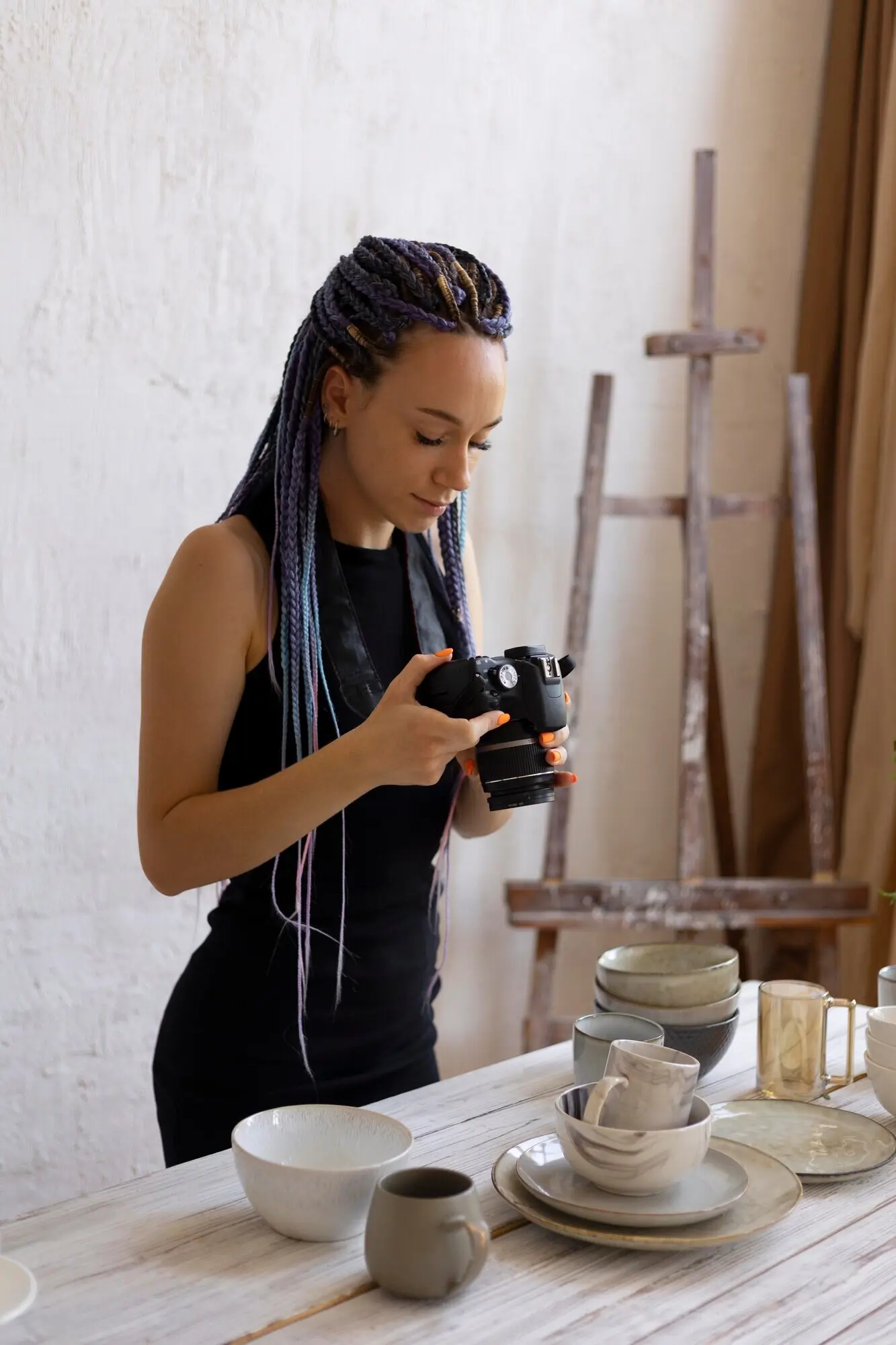 Eine Frau fotografiert zu Hause Küchengeschirr aus Keramik.